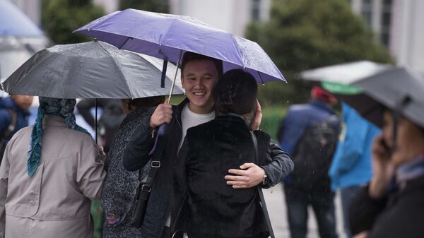 Пара под зонтиком во время дождливой погоды в Бишкеке - Sputnik Кыргызстан