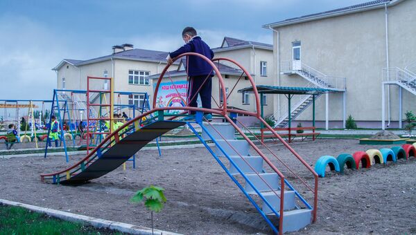 Мальчик играет на горке в детском саду. Архивное фото - Sputnik Кыргызстан