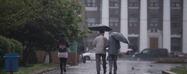 Горожане идут по улице во время дождя. Архивное фото - Sputnik Кыргызстан