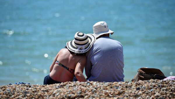 Мужчина и женщина в шляпах на пляже. Архивное фото - Sputnik Кыргызстан