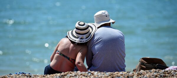 Мужчина и женщина в шляпах на пляже. Архивное фото - Sputnik Кыргызстан