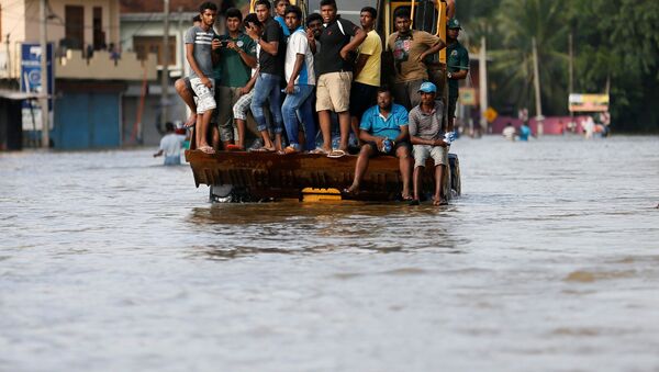 Люди на спасательной лодке в городе Биягама, Шри-Ланка. - Sputnik Кыргызстан