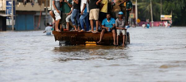 Люди на спасательной лодке в городе Биягама, Шри-Ланка. - Sputnik Кыргызстан