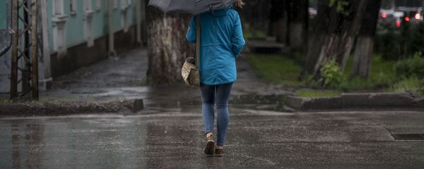 Девушка с зонтом переходит дорогу в Бишкеке. Архивное фото - Sputnik Кыргызстан