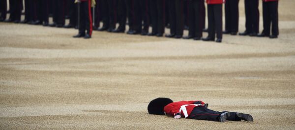 Упавший в обморок гвардеец упалу стен Букингемского дворца в Великобритании. Архивное фото - Sputnik Кыргызстан