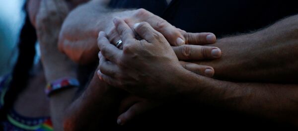 Партнеры держатся за руки после стрельбы в ночном клубе в Орландо, США. - Sputnik Кыргызстан