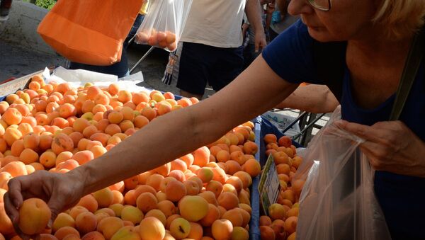 Женщина выбирает абрикосы на рынке. Архивное фото - Sputnik Кыргызстан