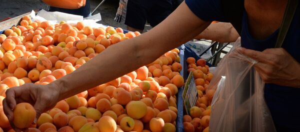 Женщина выбирает абрикосы на рынке. Архивное фото - Sputnik Кыргызстан