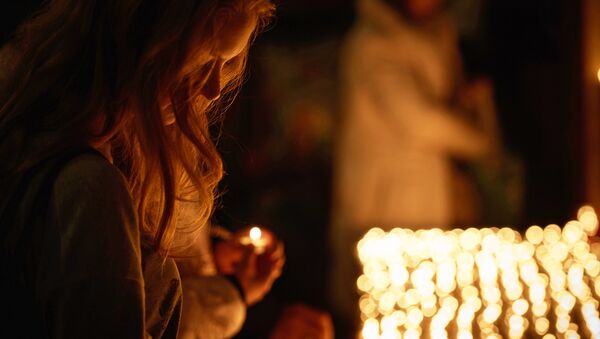 Девушка держит зажженную свечу. Архивное фото - Sputnik Кыргызстан