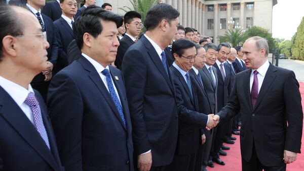 Президент России Владимир Путин (справа) во время знакомства с делегациями на церемонии официальной встречи председателем Китайской Народной Республики (КНР) Си Цзиньпином в Пекине. Архивное фото - Sputnik Кыргызстан