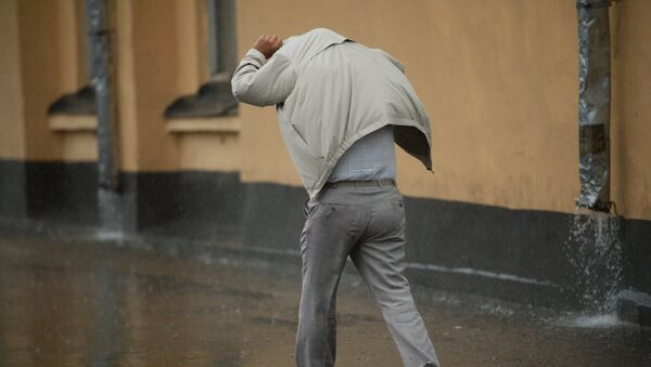 Мужчина идет по улице во время сильного дождя. Архивное фото - Sputnik Кыргызстан