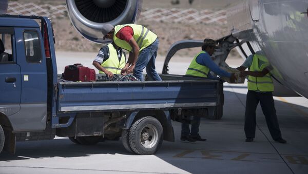 Сотрудники аэропорта загружают вещи пассажиров в самолет. Архивное фото - Sputnik Кыргызстан