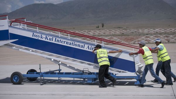 Сотрудники аэропорта устанавливают трапп для самолета в международном аэропорту в селе Тамчи, Иссык-Кульской области - Sputnik Кыргызстан