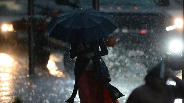 Женщина идет под зонтом во время сильного дождя. Архивное фото - Sputnik Кыргызстан