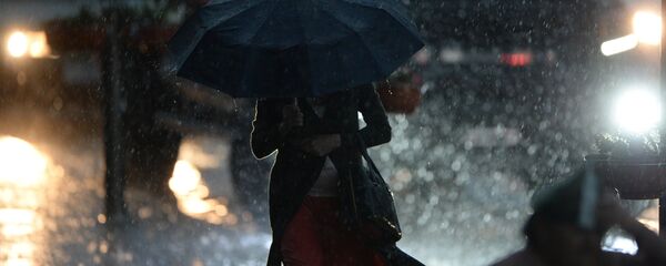 Женщина идет под зонтом во время сильного дождя. Архивное фото - Sputnik Кыргызстан