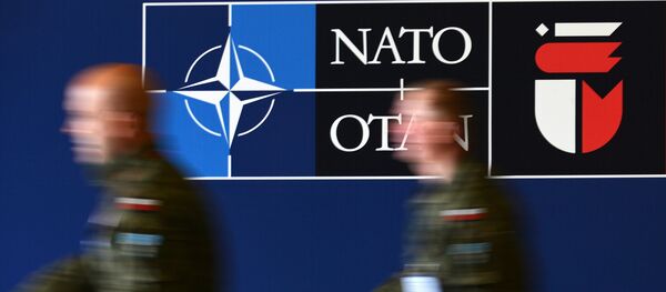 Мужчины у баннера предстоящего саммита НАТО на Национальном стадионе в Варшаве. Архивное фото - Sputnik Кыргызстан