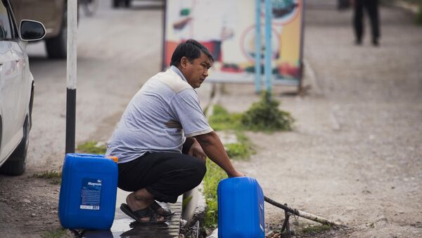 Мужчина набирает воды в канистру. Архивное фото - Sputnik Кыргызстан