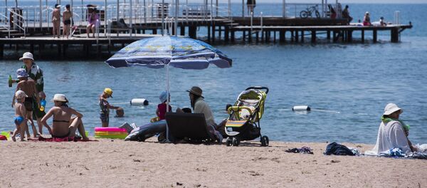 Отдыхающие на пляже озера Иссык-Куль. Архивное фото Отдыхающие на пляже озера Иссык-Куль. Архивное фото - Sputnik Кыргызстан