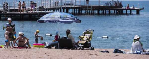 Отдыхающие на пляже озера Иссык-Куль. Архивное фото - Sputnik Кыргызстан