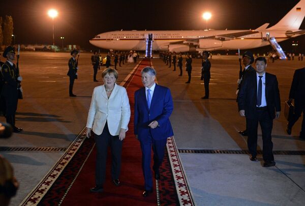 Кызыл килемде басып келе жаткан КР президенти Алмазбек Атамбаев менен Германиянын канцлери Ангела Меркель - Sputnik Кыргызстан