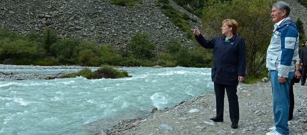 Тогдашний президент Кыргызстана Алмазбек Атамбаев и канслер Германии Ангела Меркель гуляют по парку Ала-Арча. Архивное фото - Sputnik Кыргызстан