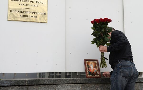 Мужчина возлагает цветы к посольству Франции в Москве в память о погибших в Ницце - Sputnik Кыргызстан