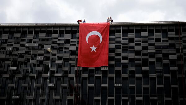 Люди с турецким флагом на здании в Стамбуле. Архивное фото - Sputnik Кыргызстан