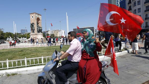 Женщина держит турецкий флаг, сидя на скутере возле площади Таксим в Стамбуле, Турция. Архивное фото - Sputnik Кыргызстан