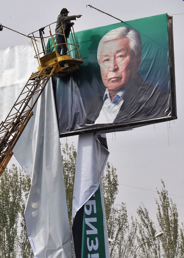Столичный работник снимает предвыборный плакат кандидата в президенты Кубатбека Байболова в Бишкеке 1 ноября 2011 года - Sputnik Кыргызстан