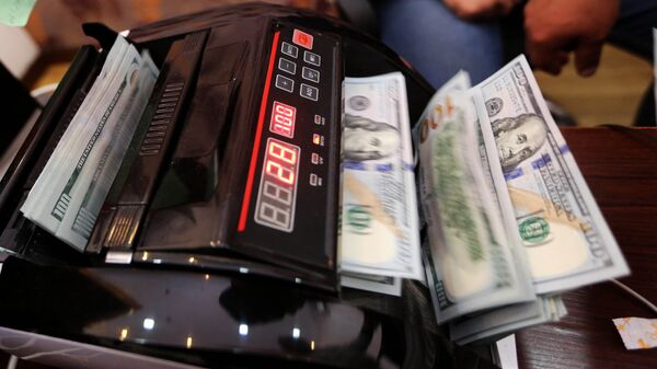Счетная машина пересчитывает доллары США. Архивное фото - Sputnik Кыргызстан