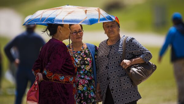 Женщины укрываются зонтом от солнца. Архивное фото - Sputnik Кыргызстан