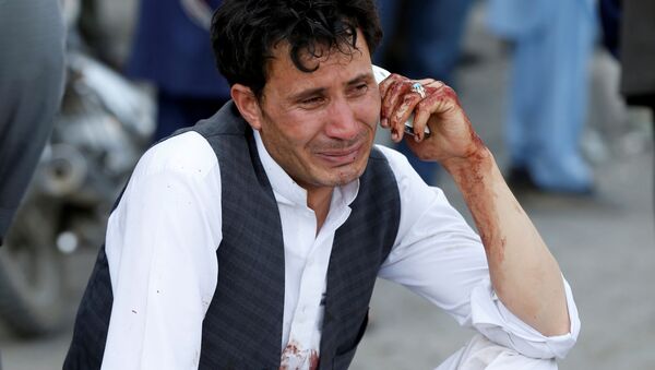 Мужчина говорит по телефону после теракта в Кабуле, Афганистан 23 июля 2016 года. - Sputnik Кыргызстан