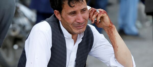 Мужчина говорит по телефону после теракта в Кабуле, Афганистан 23 июля 2016 года. - Sputnik Кыргызстан