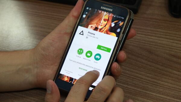 Пользователь устанавливает приложение Prisma на смартфон. - Sputnik Кыргызстан
