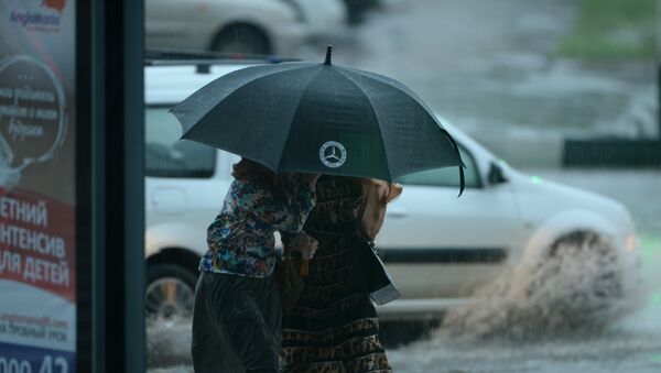 Женщины идут под зонтом во время сильного дождя. Архивное фото - Sputnik Кыргызстан