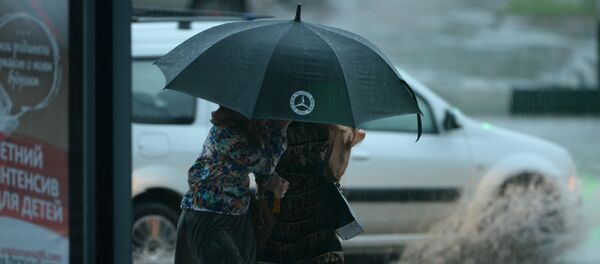 Женщины идут под зонтом во время сильного дождя. Архивное фото Женщины идут под зонтом во время сильного дождя. Архивное фото - Sputnik Кыргызстан
