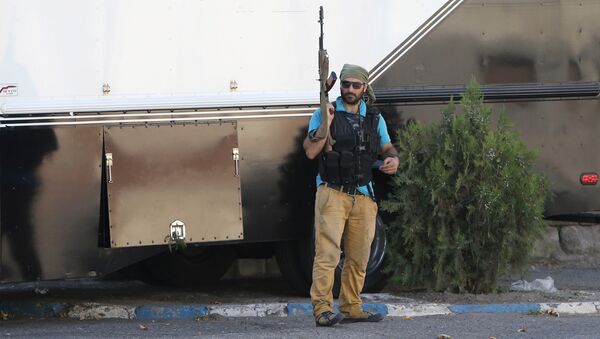Вооруженный человек стоит у захваченного здания полка патрульно-постовой службы - Sputnik Кыргызстан