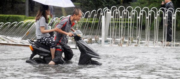 Мужчина и женщина едут на скутере во время наводнения в Пекине. Архивное фото Мужчина и женщина едут на скутере во время наводнения в Пекине. Архивное фото - Sputnik Кыргызстан