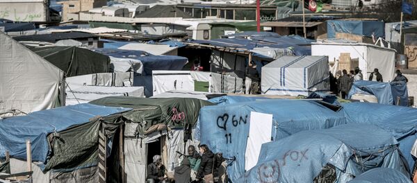 Мигранты за пределами палаток в самом большом нелегальном лагере вдоль северного побережья Франции, в портовом городе Кале. Архивное фото Мигранты за пределами палаток в самом большом нелегальном лагере вдоль северного побережья Франции, в портовом городе Кале. Архивное фото - Sputnik Кыргызстан