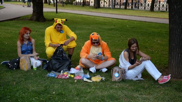 Молодые люди играют в Pokemon Go от компании Nintendo на экране мобильного телефона. Архивное фото - Sputnik Кыргызстан