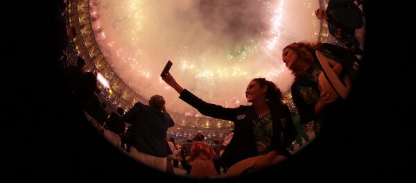 Зрители фотографируются на фоне фейерверков на церемонии открытия XXXI летних Олимпийских игр в Рио-де-Жанейро - Sputnik Кыргызстан