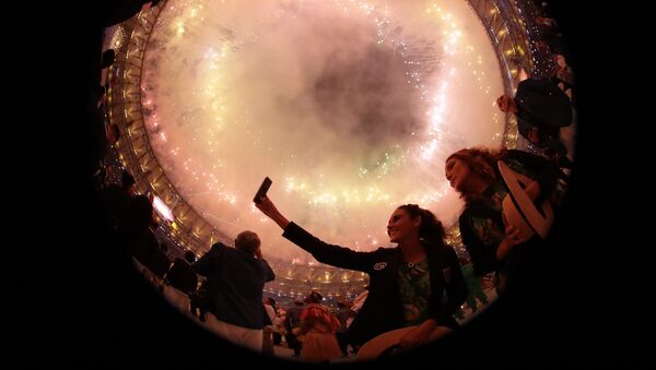 Зрители фотографируются на фоне фейерверков на церемонии открытия XXXI летних Олимпийских игр в Рио-де-Жанейро - Sputnik Кыргызстан