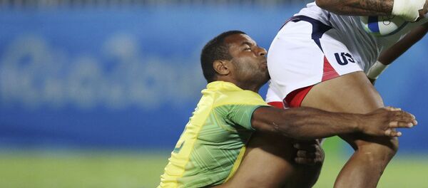 Игрок сборной Бразилии Андре Насименто держится за спортсмена из США во время регби на XXXI летних Олимпийских играх в Рио-де-Жанейро - Sputnik Кыргызстан