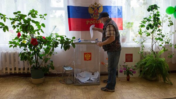 Избиратель во время голосования в России. Архивное фото - Sputnik Кыргызстан