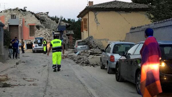 Спасатели рядом с разрушенными домами от сильного землетрясения в городе Аматриче в Италии - Sputnik Кыргызстан