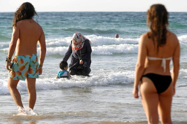 Израилдеги Тель-Авив пляжында жабык купальникчен аял. Эске салсак, Франциянын премьер-министри мусулмандарга арналган купальник кийип сууга түшүүгө тыюу салууну колдой тургандыгын билдирген. - Sputnik Кыргызстан
