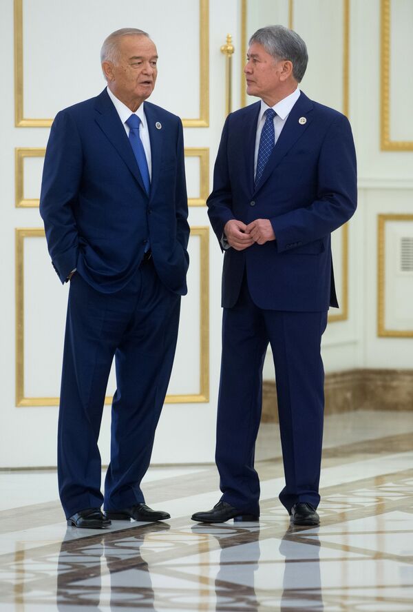 Өзбекстан президенти Ислам Каримов (солдо) жана Кыргызстан президенти Алмазбек Атамбаев ШКУга мүчө өлкөлөрдүн президенттеринин сүрөткө түшүү аземи алдында.  Иш-чара уюмдун түптөлгүндүгүнүн 15 жылдыгына карата өткөрүлгөн. - Sputnik Кыргызстан