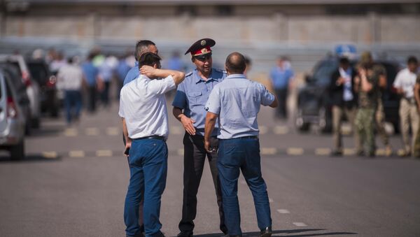 Милиционеры опрашивают свидетелей и очевидцев у дипломатического представительство Китая в Бишкеке, на территории которого произошел взрыв автомашины марки Mitsubishi Delica. - Sputnik Кыргызстан