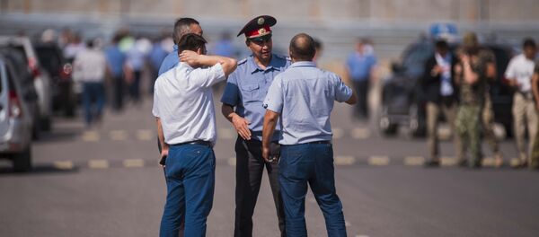 Милиционеры опрашивают свидетелей и очевидцев у дипломатического представительство Китая в Бишкеке, на территории которого произошел взрыв автомашины марки Mitsubishi Delica. - Sputnik Кыргызстан
