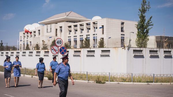 Сотрудники правоохранительных органов рядом с дипломатическим представительством Китая в Бишкеке, на территории которого произошел взрыв автомашины марки Mitsubishi Delica. - Sputnik Кыргызстан